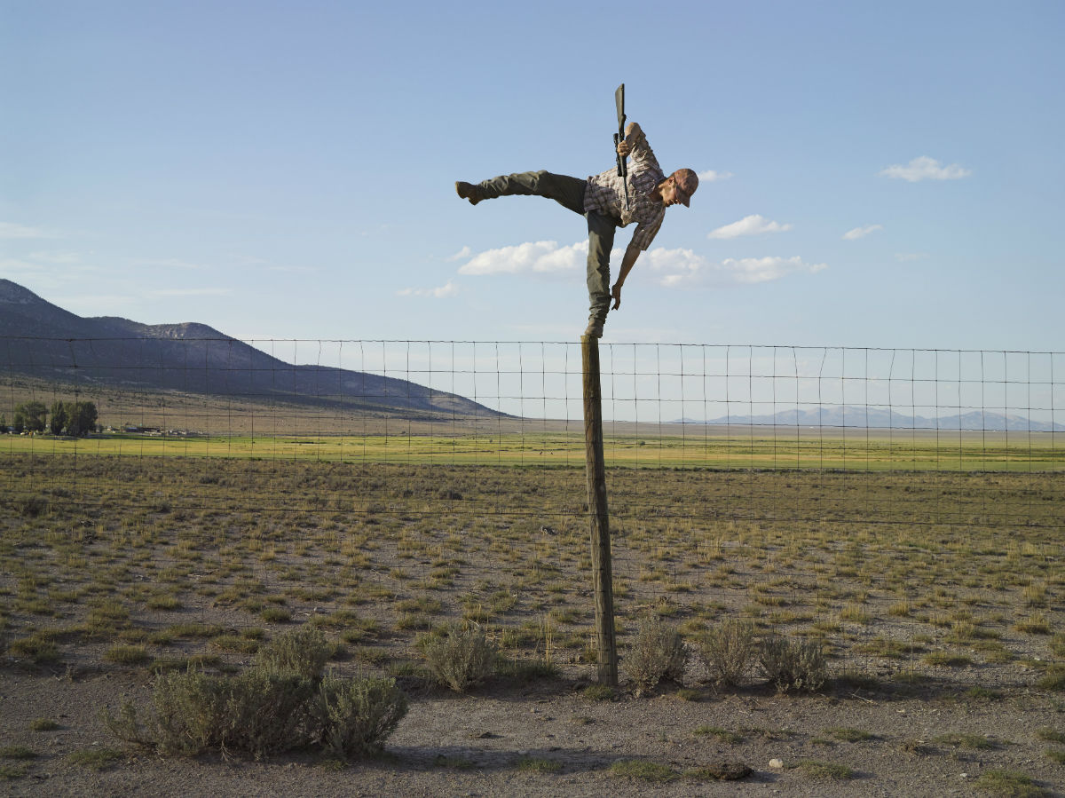 “I like to spend time with the people I photograph, to stay for long enough to take part in everyday life. It was Tommy’s idea to shoot coyotes from the top of a fence pole. I photographed Tommy the moment before he fell off the pole with a loaded gun.”